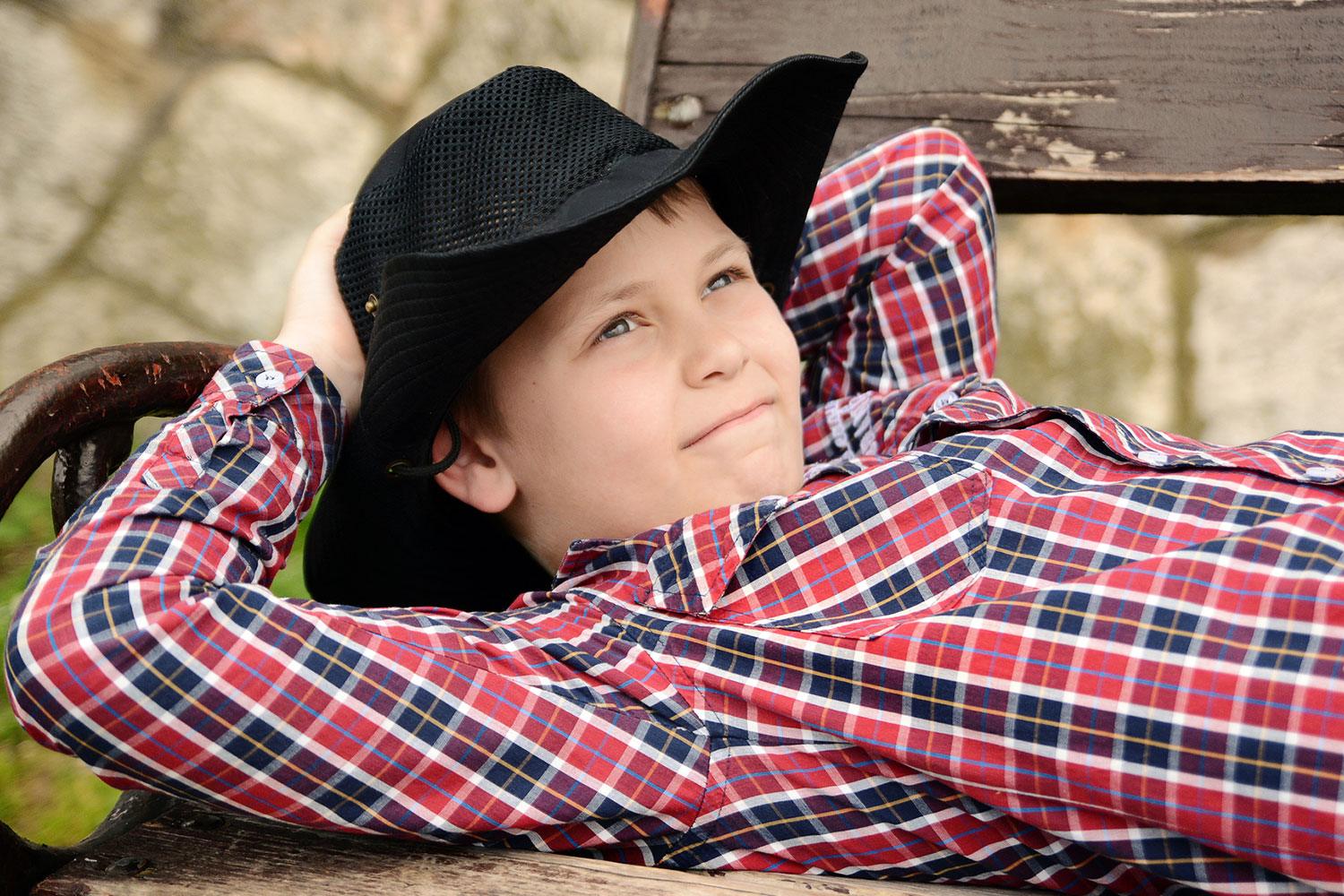 Country boy lounging on a bench